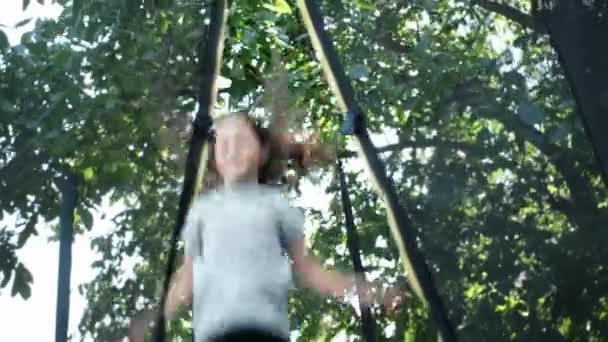 Выборочный Фокус Счастливой Красивой Девочки Прыгает Высоко Батуте Против Зеленого — стоковое видео
