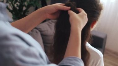 Meçhul, şefkatli anne, kızının saçını tarıyor. Sevgi dolu anne, sabahları evde güzel prematüre kız saçlarını tarıyor. Annem küçük çocuk kuyruğu saç stili yapıyor. Çocuk bakımı ve annelik kavramı