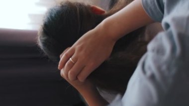 İlgili annenin küçük kızının saçını tararken, evde dikilirken, birbirlerine bağlanırken çekilmiş dikey görüntüleri. Tanınmayan anne saç stili olarak çocuk kuyruğu yapıyor. Çocuk bakımı ve annelik kavramı