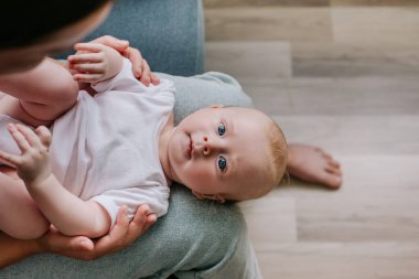 Güzel, sevecen, beyaz bir annenin evdeki rahat kanepeye oturup, tatlı bir çocuğu kucağına alıp, onunla konuşurken ya da şarkı söylerken, el ele tutuşurken ve gülümserken yan görüntüsü. Annelik kavramı