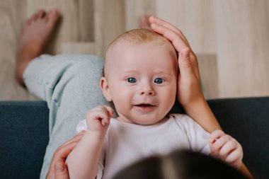 Üç aylık bebeğiyle evde rahat bir kanepede oynayıp anneliğin ve doğum izninin tadını çıkaran bir anne. Oturma odasında kucak annesi gibi yatan tatlı bir bebek. Annelik kavramı