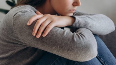 Düşünceli, endişeli, beyaz bir kadın depresyon geçiriyor. Evde yalnız ve yalnız hissediyor. Depresyondaki üzgün genç kadının kanepeye oturması, zorluklarla yüzleşmesi, başarısızlığı ve bitkinliği.