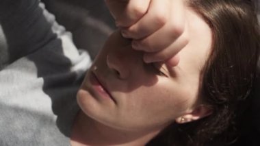 Kanepede yatan üzgün, genç, beyaz kadının yakın plan çekimi elleri ile kalp ağrısı kapağı yüzünden acı çekiyor. Ruhsal ağrıları ve ciddi sağlık sorunları olduğu için mutsuz. Boşanma kürtaj kavramı