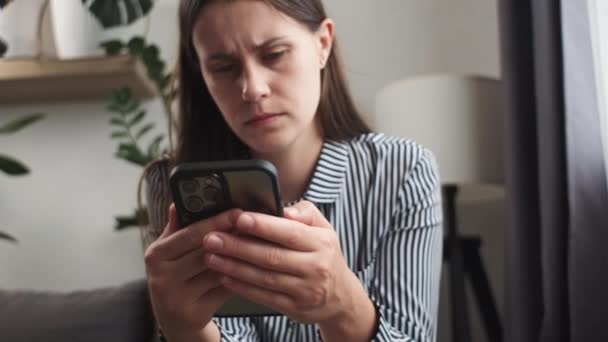 Primer Plano Mujer Joven Preocupada Molesta Sentada Sofá Sosteniendo Teléfono — Vídeos de Stock