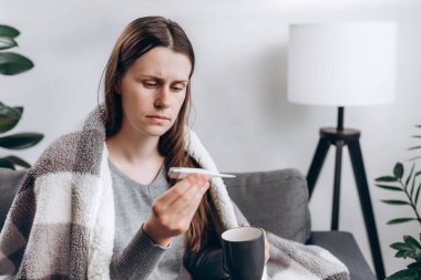Hasta genç bir kadın evdeki kanepede otururken üşüyor. Hasta kadının yüksek ateşi, migreni, ilacı, elinde bir fincan sıcak su ya da çay tutan bir kızı var. Sağlık sorunları, alerji, mevsim değişimi ateşi konsepti
