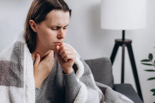 Ill young brunette female covered blanket have fever, flu or sore throat and sneezing until chest pain while rest at home. Health care with disease, pandemic virus, coronavirus or covid-19 concept