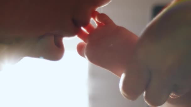 幸せな若い愛する母親の垂直ビデオ穏やかに家の暖かい日光で小さな足にキス 新生児の小さなつま先 子どものつながり ケアコンセプト — ストック動画