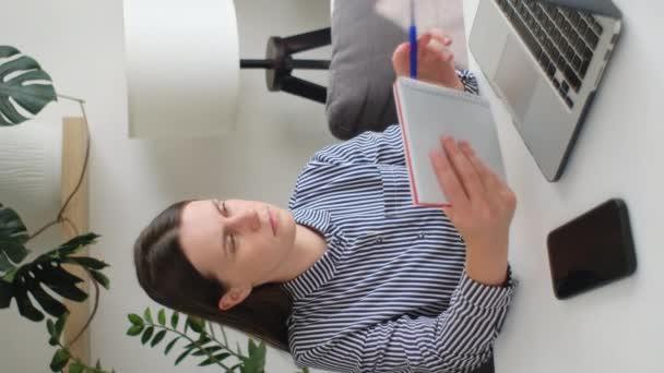 Вертикальный Снимок Серьезной Молодой Внештатной Предпринимательницы Сидящей Столом Делающей Бумажную — стоковое видео