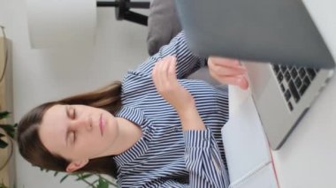 Aşırı çalışan genç bir kadının dikey görüntüleri bilgisayar başında yorgunluk göz yorgunluğu çekiyor, beyaz bir kız öğrencinin kuru gözlerinde ağrı, görme bozukluğu var.