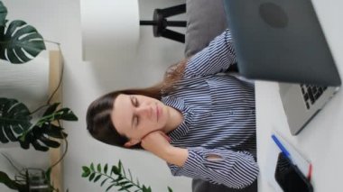 Çekici, düşünceli genç bir kadının uzaktan bilgisayarı kullanarak çalışırken çekilmiş dikey görüntüleri, online sunum üzerinde kafa yorma, web sörfü bilgileri internette zaman geçirme, serbest çalışma.
