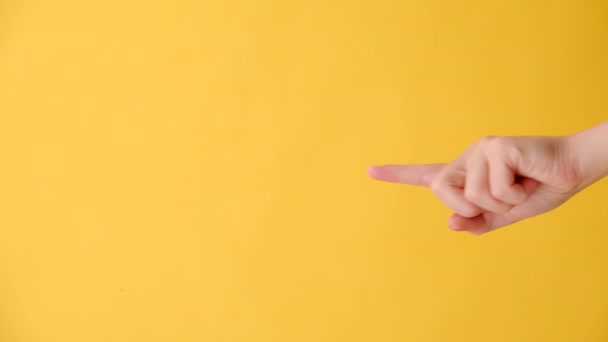 黄色い空白の宇宙商業背景ループの空白の領域を示している女性の手指の垂直映像 サインをおすすめします テキストかイメージのための場所を使って スペシャルオファーコンセプト — ストック動画