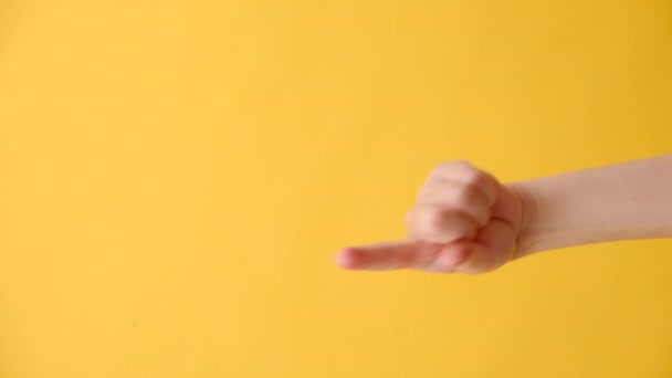 女性の手の縦の映像はあなたを指し 広告のためのコピースペースが付いている黄色い色の背景でより密接に来ます ボディランゲージコンセプト テキストまたはプロモーションコンテンツの場所 — ストック動画