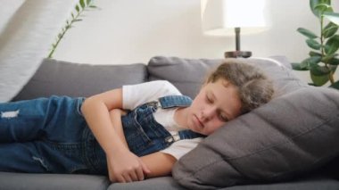 Küçük hasta kızına göz kulak olan genç anneye yakın ol. Hasta çocuğun battaniyenin altında yatarken yüksek ateşi var. Bekar beyaz anne, evdeki oturma odasında hasta kıza bakıyor.