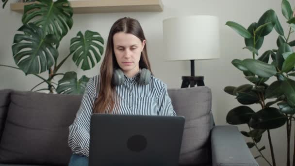 Όμορφη Νεαρή Γυναίκα Που Χρησιμοποιεί Φορητό Υπολογιστή Κάθεται Άνετο Καναπέ — Αρχείο Βίντεο