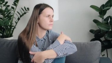 Yalnızlığı düşünen depresif bir kadın, suçluluk hisseder, zor kararlar verir. Endişeli genç bir kadın koltukta oturup sorun için endişeli, zihinsel stresten muzdarip, pişman.