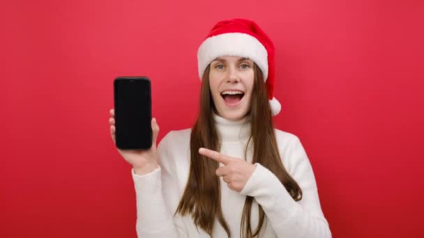 Mujer Joven Alegre Lleva Suéter Blanco Sombrero Santa Claus Apuntando — Vídeo de stock