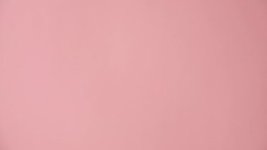 Alkışları alkışlayan kadınların dikey videosu. Stüdyoda, reklam ve tasarım için fotokopi alanı olan pastel pembe arka plan duvarında izole edilmiş. Reklam alanı, modelle. Alkış ya da alkış kavramı