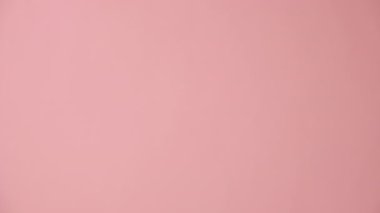 Dikey videoda kadın baş parmak hareketi yapıyor, onay ya da anlaşma gösteriyor, pembe arka planda izole edilmiş, reklam ve tasarım için fotokopi alanı var. Vücut dili kavramı. Jest gibi