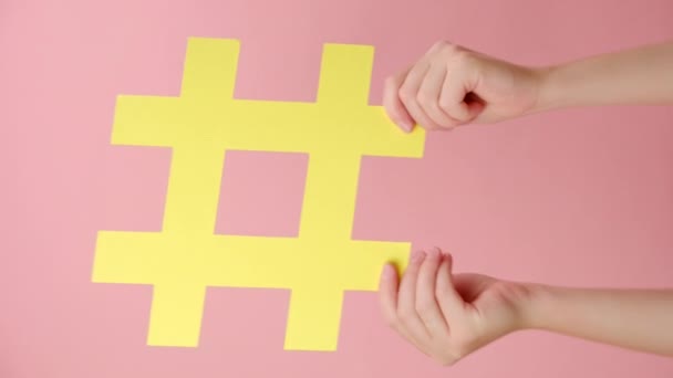 Vídeo Vertical Mãos Femininas Segurando Grande Símbolo Hashtag Papel Amarelo — Vídeo de Stock