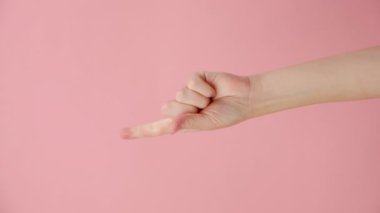 1 'den 5' e kadar parmakları olan, pembe arka planda izole edilmiş ve reklam için fotokopi çeken kimliği belirsiz genç bir kadının dikey videosu. Metin ya da görüntü için yer var. El hareketi. Hesaplanan numaralar