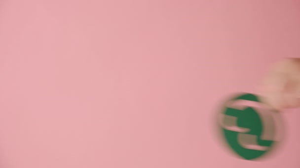 女性手握着正面绿色笑脸的垂直视频 在工作室的彩色粉红背景墙上放置隔离 并提供复制空间用于促销内容或设计 情感概念 — 图库视频影像