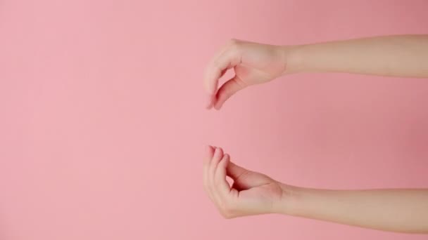 在演播室里 流言蜚语的女性手指的垂直视频 在粉红色的背景墙上摆出孤立的姿势 并有复制空间来做促销内容 Blah手 说话姿势的概念 对话交流 — 图库视频影像