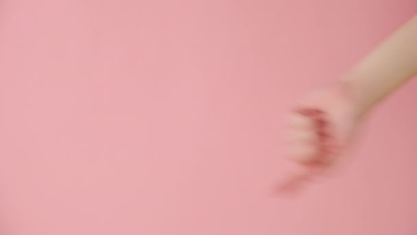 Вертикальне Відео Жіночої Руки Показує Ізольовано Над Рожевою Стіною Студійного — стокове відео