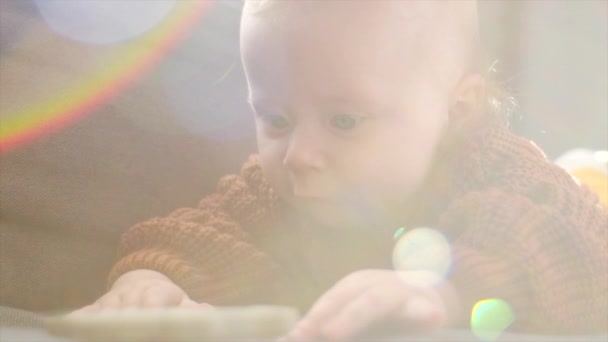 可爱的小孩儿摸着玩具躺在舒适的沙发上 可爱的小宝宝穿着温暖的棕色毛衣 在客厅里玩着 童年概念 — 图库视频影像