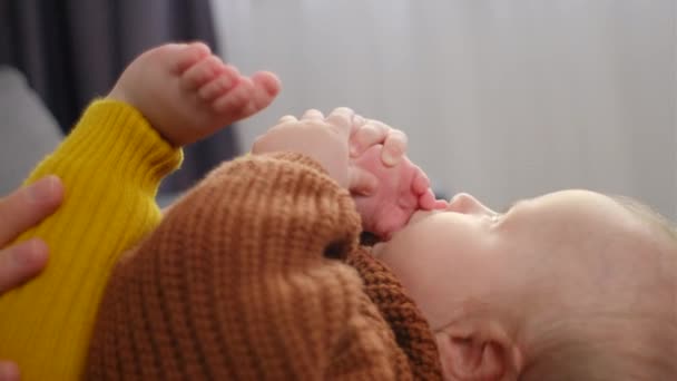 Zbliżenie Zabawnego Słodkiego Noworodka Trzymającego Ssącą Stopę Kolanach Matki Domu — Wideo stockowe