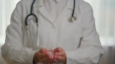 Ekim Kanser Farkındalığı Ayı. Kadın doktorun elinde pembe kurdele var. İnsanların hayatını ve hastalıklarını desteklemek için hastanede. Ulusal Kanser Kurtulanlar Ayı, Anneler ve Dünya Kanser Günü konsepti