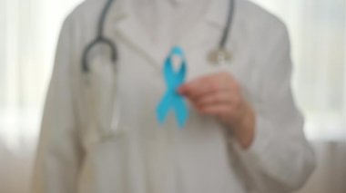 Steteskoplu, mavi kurdeleli, üniformalı, kimliği belirsiz bir kadın doktoru yakından takip edin. Kasım ayında erkek sağlığı ve prostat kanseri bilinçlendirme kampanyası. Tıbbi sorunların sembolü