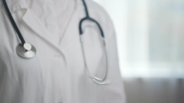 一名身穿白色制服的无名年轻女医生手持听诊器 手里拿着少量红药丸维生素 接受维生素或药物治疗 制药和保健概念 — 图库视频影像