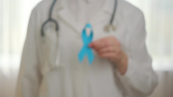 近距离的不知名女医生制服与听诊器持有小蓝带意识 男子健康与前列腺癌意识运动于11月展开 医疗问题的符号 — 图库视频影像