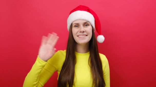 Śliczna Uśmiechnięta Młoda Kobieta Nosi Żółty Sweter Kapelusz Świętego Mikołaja — Wideo stockowe