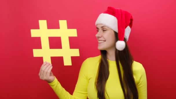 Viehättävä Nuori Nainen Jolla Keltainen Hashtag Symboli Joka Näyttää Peukaloa — kuvapankkivideo