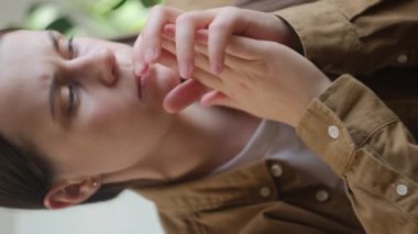 Evdeki kanepede oturan endişeli kadının dikey görüntüsü. Hayal kırıklığına uğramış kız mutsuz hissediyor, özel hayatındaki sorunlar, erkek arkadaşından ayrılması ve beklenmedik hamilelik kavramı.