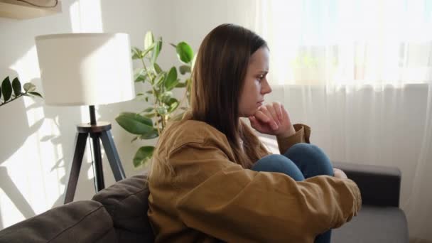 忧心忡忡的年轻的高加索女人因感情问题而沮丧 独自坐在沙发上 抱着膝 感到绝望和焦虑 有心理问题 — 图库视频影像