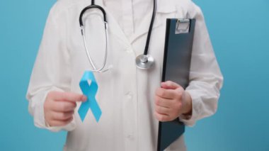 Mavi kurdeleli, beyaz üniformalı, tanınmayan kadın doktorlara yakın çekim. Kasım ayında erkek sağlığı ve prostat kanseri bilinçlendirme kampanyası. Tıbbi sorunların sembolü