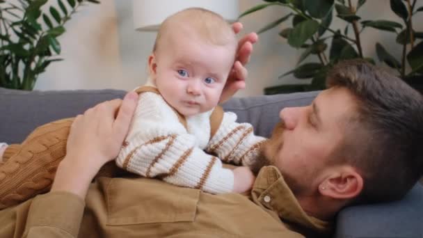 Überglücklicher Junger Vater Der Sich Auf Dem Bequemen Sofa Gemütlich — Stockvideo