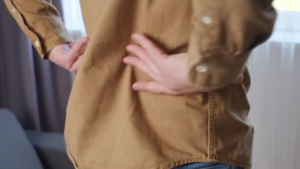 近距离观察未知不健康的30多岁的年轻高加索男子穿着棕色衬衫摸着受伤的背痛 腰部不适 过度劳累造成肌肉疼痛 神经抽筋 背痛的概念 — 图库视频影像