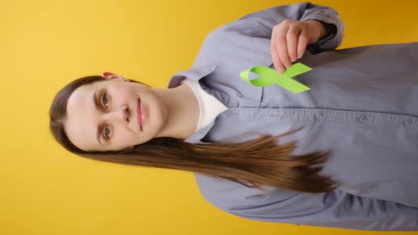 Вертикальное Видео Молодой Женщины Держащей Маленькую Лаймово Зеленую Ленту Позирующую — стоковое видео