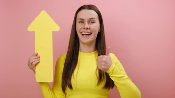 Satisfied Young Brunette Woman Holding Yellow Arrow Pointing Looking Camera — Stock Video