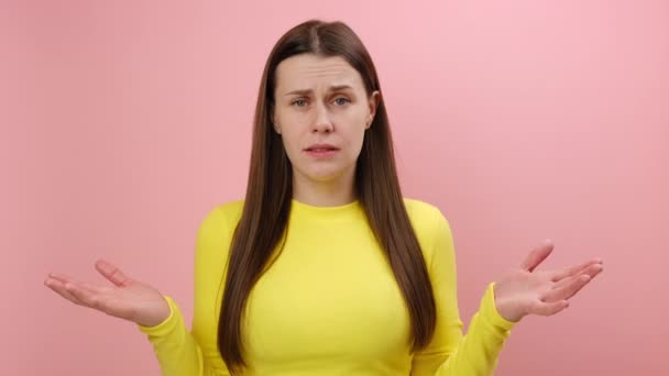 怒气冲冲的年轻女人 身穿黄色毛衣 怒气冲冲地举起双手 为什么 你想要什么 — 图库视频影像