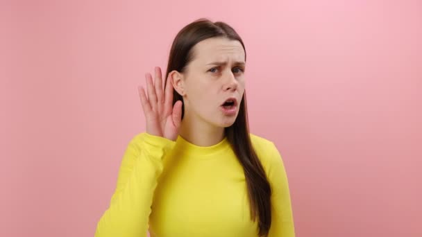 Портрет Заплутаної Молодої Брюнетки Тримає Руку Біля Вуха Щоб Слухати — стокове відео