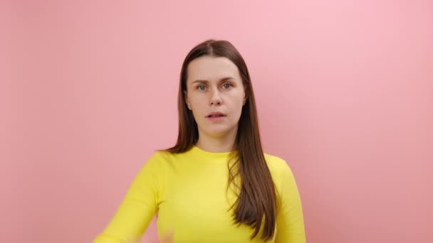 怒りの肖像画は 若い白人女性が額に手でゆるやかなジェスチャーを示し 黄色いセーターを着用し スタジオのピンク色の背景壁の上に隔離された 失敗するコンセプト — ストック動画