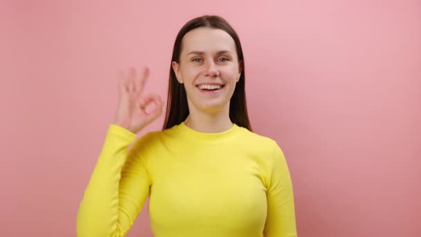 Portret Uroczej Młodej Białej Kobiety Ukazującej Znak Patrzącej Aparat Szczęśliwym — Wideo stockowe