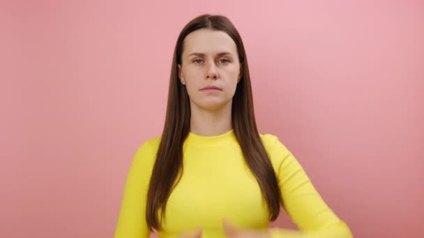 スタジオでピンク色の背景の壁に隔離された黄色のセーターを着て 期限を心配して 手のジェスチャーを見せる不満の若い白人女性の肖像画 — ストック動画