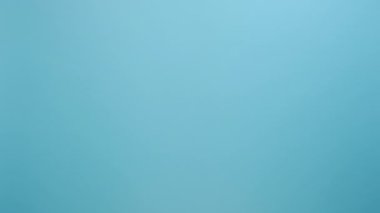 Kadının elinde küçük pembe kurdele, göğüs kanseri farkındalığının sembolü, onkolojik hastalıkların önlenmesi ve kadın sağlık hizmetleri, stüdyoda mavi renkli arka plan duvarı üzerinde izole edilmiş pozlar