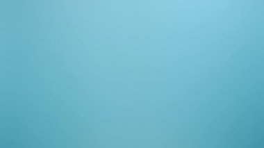 Kadının elinde küçük pembe kurdele, göğüs kanseri farkındalığının sembolü, onkolojik hastalıkların önlenmesi ve kadın sağlık hizmetleri, stüdyoda mavi renkli arka plan duvarı üzerinde izole edilmiş pozlar