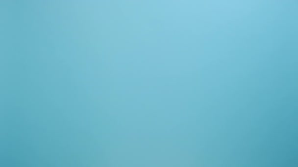 緑のリボンを握っている女性の手の近くに 広告のためのコピースペースが付いているスタジオの青い色の背景の壁の上に隔離されたポーズ 腎臓がん意識コンセプト — ストック動画